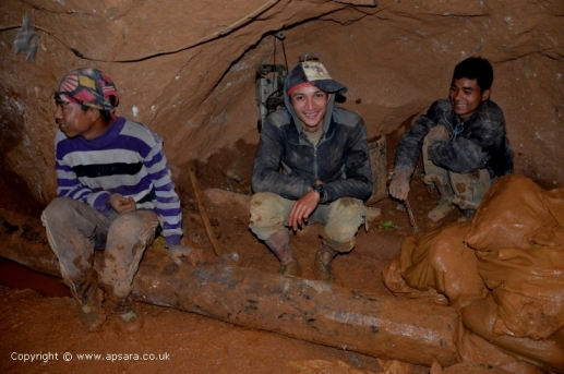 Miners in the mine next to sacks of soil